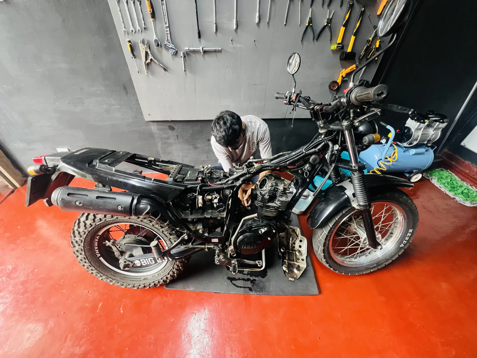MK Motors mechanic working on a stripped Yamaha TW in the Borella workshop